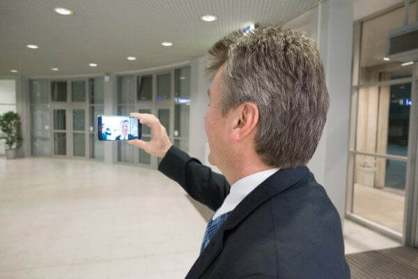 Christian macht einen Selfie-Aufsager mit dem Smartphone.
